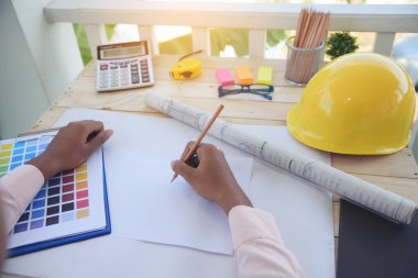 Ofis masasında çalışan inşaat mühendisi elleri. Mühendis Adam elleri klasör çiziyor, ofis masasında akıllı telefon kullanıyor belge taslağı çiziyor.