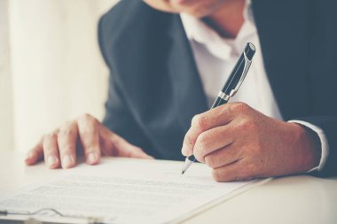 Asian business man using pen signing on new contract to starting projects in conference room. Close up manager businessman hands sign contract working meeting. Business agreement concepts.