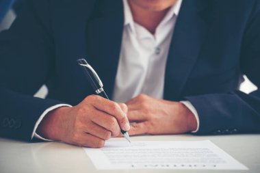 İş adamı, konferans odasında yeni sözleşme imzalamak için kalem kullanıyor. İşletme müdürü toplantı odasında kontrat imzaladı. İş anlaşması kavramı