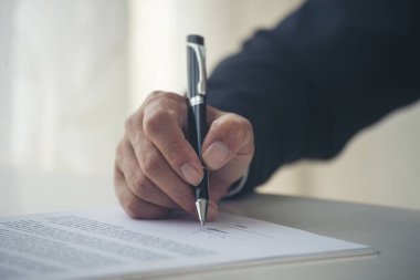 Asian business man using pen signing on new contract to starting projects in conference room. Close up manager businessman hands sign contract working meeting. Business agreement concepts.