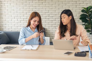 Finansal grafik grafiklerini okuyan iki Asyalı kadın pazarlama verilerini analiz etmeyi planlıyor. Asyalı takım çalışanı ofis firması. Şirket masasında dizüstü bilgisayarla iki iş kadını buluşması..