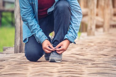 Adam, işçi için ip kravat bağlama, ayakkabı endüstrisi botları dizlerinin üzerine çöker. Erkek eli, kahverengi çizmeleri için ayakkabı bağı bağlamış. Yakın plan erkek elleri ayakkabı konsepti için ayakkabıları bağlar..