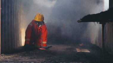 Firefighter Rescue training in fire fighting extinguisher. Firefighter fighting with flame using fire hose chemical water foam spray engine. Fireman wear hard hat, safety suit uniform for protection