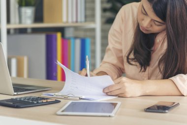 Ev ofis masasında dizüstü bilgisayar kullanan Asyalı kadın serbest yazar. Finansal grafik çizelgesi okuyan kadın pazarlama verilerini analiz ediyor. Ofiste çalışan Asyalı kadınlar, iş konuları, kahve fincanları.