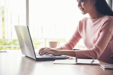 Ev bilgisayarında çalışan bir kadın merkez ofiste online toplantı yapıyor. Dizüstü bilgisayar kullanan girişimci Asyalı iş kadını kanepe teknolojisinde yeni normal yaşam tarzında oturuyor. Klavye dizüstü bilgisayarı yazan mutlu kadın