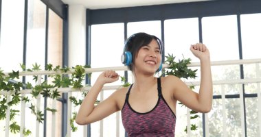 Yoga woman workout listen music. Beautiful woman smile in sportswear sit on yoga mat home fitness workout exercise. Happy beauty women dance on floor use headphone listen to music wellness lifestyle