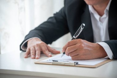 Kapanış müdürü iş adamı sözleşmeli iş görüşmesi imzaladı. Asyalı iş adamı, konferans odasında projelere başlamak için kalem imzası kullanıyor. İş anlaşması kavramları.