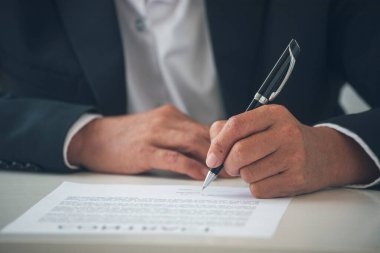 İş adamı, konferans odasında yeni sözleşme imzalamak için kalem kullanıyor. İşletme müdürü toplantı odasında kontrat imzaladı. İş anlaşması kavramı