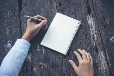 İş kadınının elinde bir belge var. Elleri boş deftere yazılmış. Çevresel sürdürülebilir açık hava üzerinde çalışan bir kadın. Boş çizim defterine kalem tutan kadın. Model Konsepti