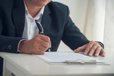 Asian business man using pen signing on new contract to starting projects in conference room. Close up manager businessman hands sign contract working meeting. Business agreement concepts.