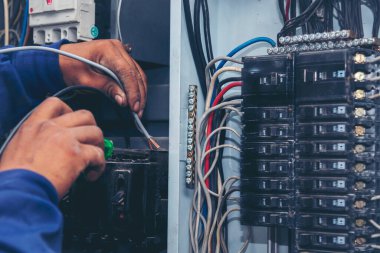 Müfettişler santralde çalışan makine bakım servisini teslim etti. Elektrik teknisyeni elektrik kablosunu kontrol etti. Elektrikçi devre onarım voltajı. Erkek eli şalteri tamir eder