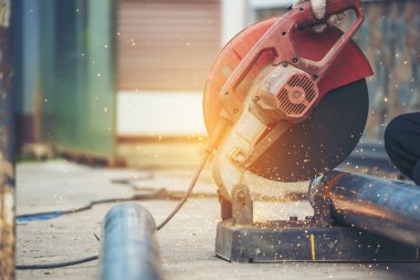 Kaynak makineleri demir metal kıvılcımlar saçıyor. Kızgın alev kaynağı metal işçiliği ateş demir atölyesini kesiyor. Çilingir kaynak makinesi kullanarak metal işlem öğütücüsünü kesiyor. Ağır Mühendis Metal Fabrikası