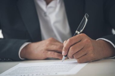 İş adamı, konferans odasında yeni sözleşme imzalamak için kalem kullanıyor. İşletme müdürü toplantı odasında kontrat imzaladı. İş anlaşması kavramı