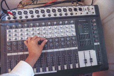 Üretim ses mühendisi kadın elleri ses dengeleyici sesi ayarlıyor, konsolu karıştırıyor. DJ ses mühendisliği stüdyonun ses kontrolü üzerinde çalışıyor. Yapımcı remix müzik ses kaydı
