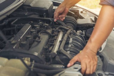 Tamirci araba tamirhanesini kapatırken araba tamircisini de eline aldı. Makineli araç mekanik servisini tamir eden adam elleri. Araç kaputu otomobili kontrol ediyor. Araç bakım mühendisi.