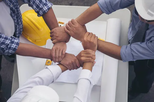 Close up engineer men hands diversity multiethnic partners team together. Group of multiracial people Engineer Manager Foreman Teamwork meeting join hands. Top view office table team join partnership