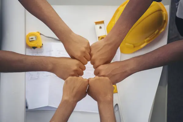 Close up engineer men hands diversity multiethnic partners team together. Group of multiracial people Engineer Manager Foreman Teamwork meeting join hands. Top view office table team join partnership