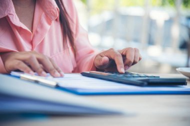 Evde çalışan Kadın Eller ufak tefek işler yapıyor. Ofis masasındaki iş kadını denetçisi. İş kadını, muhasebe denetçisine hesap makinesi ve iş grafiği çizelgesi kullanarak el uzatıyor..