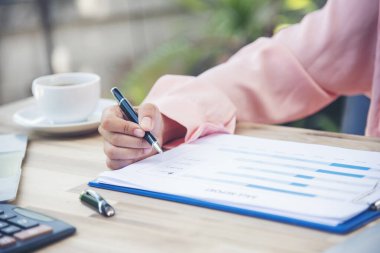 Evde çalışan Kadın Eller ufak tefek işler yapıyor. Ofis masasındaki iş kadını denetçisi. İş kadını, muhasebe denetçisine hesap makinesi ve iş grafiği çizelgesi kullanarak el uzatıyor..