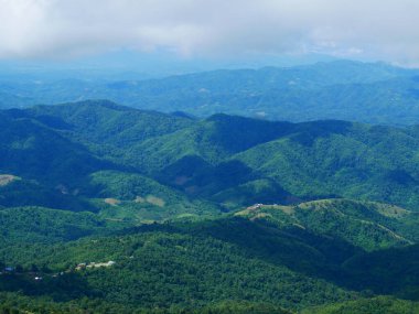 Dağ manzarasında dramatik bir gün batımı. Güzel manzara sisli tepeler alacakaranlık vakti. Mavi altın gökyüzü gün doğumu dramatik manzara dağları. Şafak vakti altın rengi alacakaranlık zamanı güneş ışığıyla bulutlu manzara