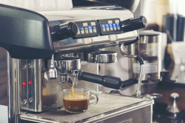 Close up hands coffee barista man make hot cup espresso shot from coffee machine. Cappuccino with milk in italian coffee shop cafe. Close up hands of barista use machine make black drinking hot cup