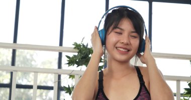 Yoga woman workout listen music. Beautiful woman smile in sportswear sit on yoga mat home fitness workout exercise. Happy beauty women dance on floor use headphone listen to music wellness lifestyle