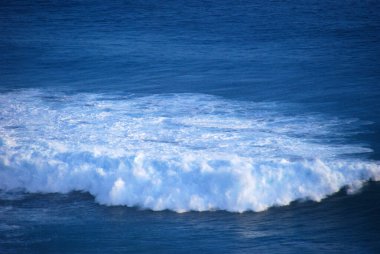 Mavi deniz deniz okyanusu, bulanık arka planda tropikal dev bir dalga. Açık havada deniz mavisi okyanus beyaz dalgası hareketi. Aqua marine dev dalga deniz yaz arkaplanı. Turkuaz cennet su manzarası