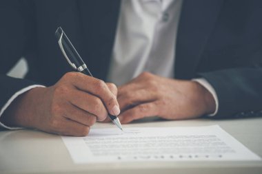 Asian business man using pen signing on new contract to starting projects in conference room. Close up manager businessman hands sign contract working meeting. Business agreement concepts.