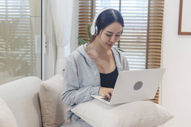 Ev ofisinde bilgisayarla bilgisayar kullanarak çalışan Asyalı kadının mutluluğu. Keyfine bak Asyalı iş kadını klavye yazıyor dizüstü bilgisayar kullanıyor gülümsüyor, ev ofisine gülüyor..