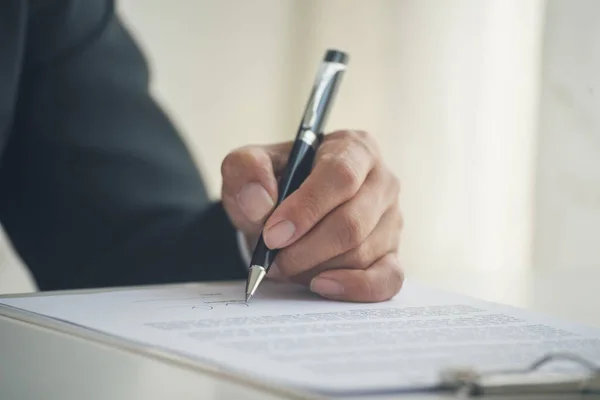Businessman hand using pen signing on new contract to starting projects in conference room. Close up business manager man hands sign contract legal document in meeting room. Business agreement concept