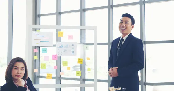 Happy business people meeting present graph chart investment, business data in meeting room. Group of business people meeting in conference room. Asian businessman speech, present teamwork partnership