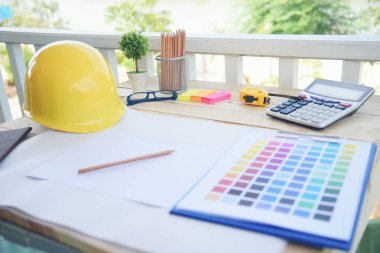 İnşaat mühendisi, ofis masası mimar işyeri. Mühendis, üzerinde metre, plan ve inşaat başlığı olan nesneler çiziyor. Tasarımcı Nesneler ahşap masada çalışma alanı çiziyor.