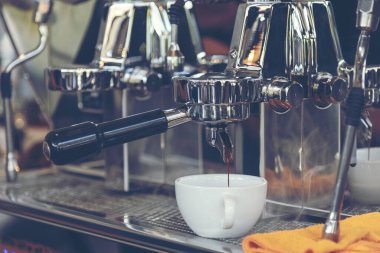 Close up hands coffee barista man make hot cup espresso shot from coffee machine. Cappuccino with milk in italian coffee shop cafe. Close up hands of barista use machine make black drinking hot cup