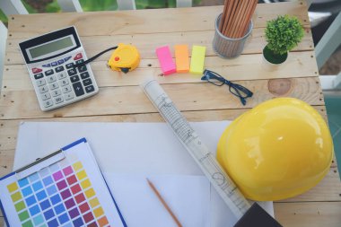 İnşaat mühendisi, ofis masası mimar işyeri. Mühendis, üzerinde metre, plan ve inşaat başlığı olan nesneler çiziyor. Tasarımcı Nesneler ahşap masada çalışma alanı çiziyor.