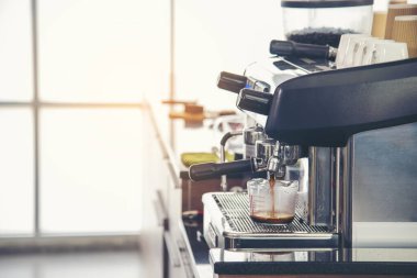 Close up hands coffee barista man make hot cup espresso shot from coffee machine. Cappuccino with milk in italian coffee shop cafe. Close up hands of barista use machine make black drinking hot cup