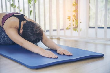 Kadınlar yoga meditasyonu geriliyor, kollar evde meditasyon yapıyor yerde. Yoga yapan genç kadınların mutluluğu Balasana çocuk pozu. Spor giyim sektöründeki sağIıklı kadın rahatlama, rahatlama ve sağlık hizmetlerinde meditasyon yapıyor.