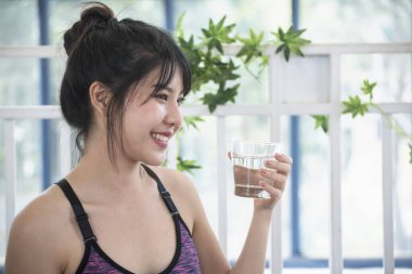 Su içen kadın elinde soğuk maden suyu, soğuk içecek. Asyalı kadınların gülüşü sağlık hizmetlerinin yaşam tarzını göz ardı ediyor. Neşeli güzel bayan bir bardak su gülümseyen surat iç.