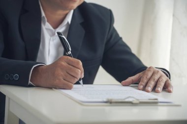 Asian business man using pen signing on new contract to starting projects in conference room. Close up manager businessman hands sign contract working meeting. Business agreement concepts.