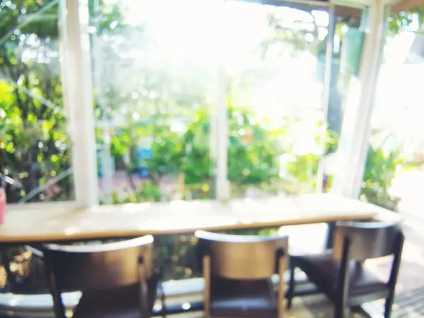 Blurry background interior design bar table chair window decorate indoors space display. Blurred background cafe coffee shop restaurant in shopping mall with light bokeh business event retail store