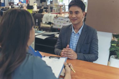 İnsan Kaynakları İK memurunun iş görüşmesi. Yeni çalışanın gülümseyen yüzüyle ofiste tokalaşması. İnsan Kaynakları Müdürü 'nün sorgulama özgeçmişi, yüz yüze. İş Görüşmesi Konsepti