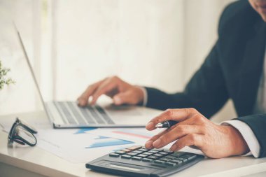 Yakın plan Asyalı işadamına hesap numarasını, iş planlama raporunu, Asyalı iş adamının ellerini hesap makinesi kullanarak hesap makinesini, vergi faturasını verdi. Vergi denetimi finans kavramı