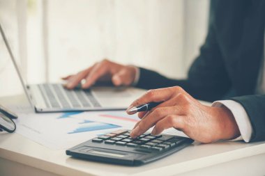 Yakın plan Asyalı işadamına hesap numarasını, iş planlama raporunu, Asyalı iş adamının ellerini hesap makinesi kullanarak hesap makinesini, vergi faturasını verdi. Vergi denetimi finans kavramı