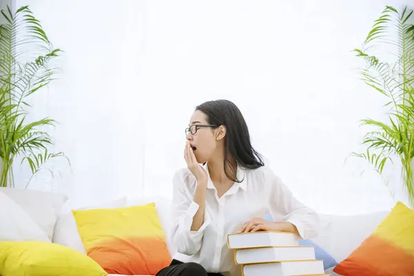 Young asian woman reading book on cozy couch sofa at warm hom. Relax woman holding book read on sofa near window happiness.woman reading open book leisure mind. Happiness woman lifestyle at home