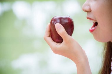 Genç Asyalı kadın Apple Sağlıklı yiyor. Organik elma meyvesi tutan kız sporu sağlıklı bir yaşam tarzı. Sağlıklı Asyalı kadınlar kırmızı elma gülüşü yiyor. Kameraya bak. Güzellik sağlık yaşam tarzı konsepti