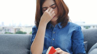 Asyalı kadınlar evdeki küçük ofis masasından akıllı telefon aracılığıyla konuşurlar. Genç Asyalı Kadın elleri telefon teknolojisi yaşam tarzını tutuyor. Mutlu kadın arayan kişi ev ofisinde dijital akıllı telefon kullanıyor.