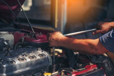 Otomobil makinelerinin mekanik servisini tamir eden elleri kapatın. Tamirci araba tamirhanesini tamir ederken ellerini kaldırdı. Araç kaputu otomobili kontrol ediyor. Araç bakım mühendisi.