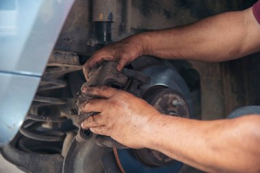 Tamirci araba tamirhanesini kapatırken araba tamircisini de eline aldı. Makineli araç mekanik servisini tamir eden adam elleri. Araç kaputu otomobili kontrol ediyor. Araç bakım mühendisi.