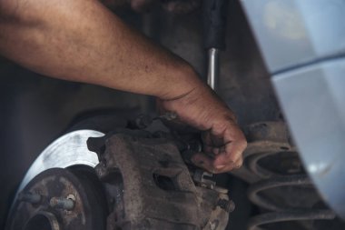 Tamirci araba tamirhanesini kapatırken araba tamircisini de eline aldı. Makineli araç mekanik servisini tamir eden adam elleri. Araç kaputu otomobili kontrol ediyor. Araç bakım mühendisi.