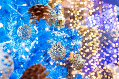 Noel ağacında süslenmiş mavi, pırıl pırıl mücevherler. Mevsimlik tatiller, yeni yıl festivali kutlamaları. Bulanık arka plan Açık altın top Mavi Noel ağacı