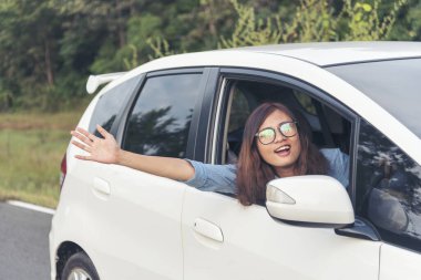 Mutlu Asyalı kadınlar yeni araba kullanır. Kadın El, kiralık araba servisine uzaktan kumandalı araba anahtarı veriyor. Ellerini kapat genç bayan, yeni araba anahtarını gösteriyor. Kadın sürücü, araba kiralama servisinde gülen surat yapıyor.